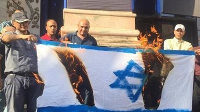 متظاهرون يحرقون علم إسرائيل احتجاجًا على زيارة 
