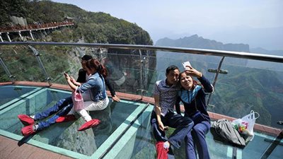 بالفيديو..السائحين على سطح أعلى وأطول ممشى زجاجي فى الصين