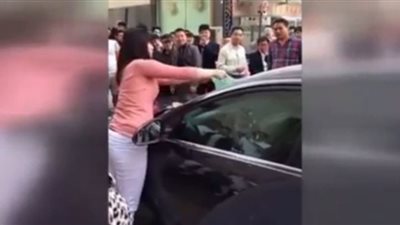 بالفيديو.. امرأة تحطم سيارة زوجها بيديها وهو يختبئ بداخلها