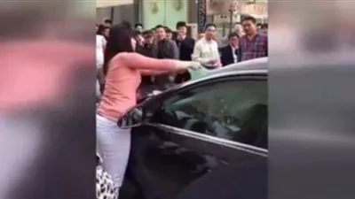 بالفيديو.. امرأة تحطم سيارة زوجها بيديها وهو يختبئ بداخلها